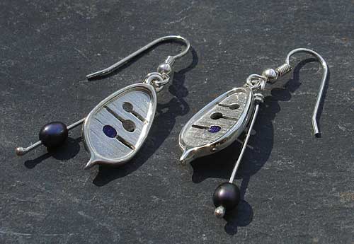 Celtic earrings with enamel detail and peacock pearls threaded onto a silver wire