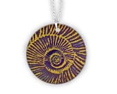 Titanium ammonite pendant featuring a flowing spiral shell design