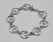 Sterling silver textured circle bracelet featuring individually formed links