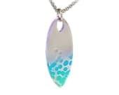 Surfboard titanium necklace showcasing a flowing ripple finish