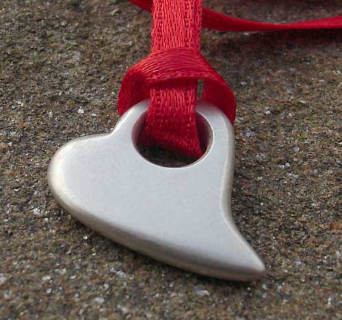 silver heart pendant on red ribbon