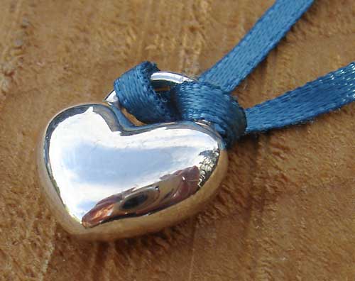 polished silver heart on a ribbon
