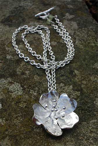 silver flower pendant on chain