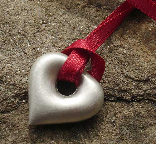 silver heart pendant on red ribbon
