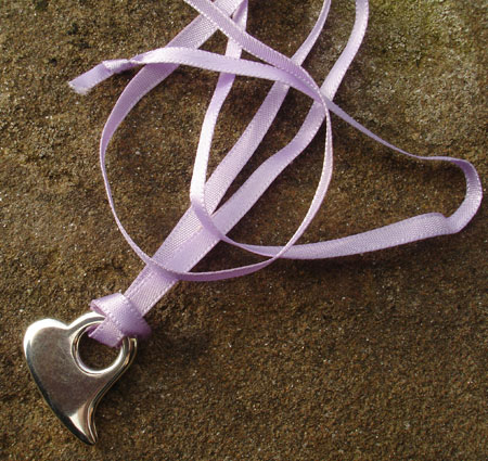 silver heart pendant on purple ribbon