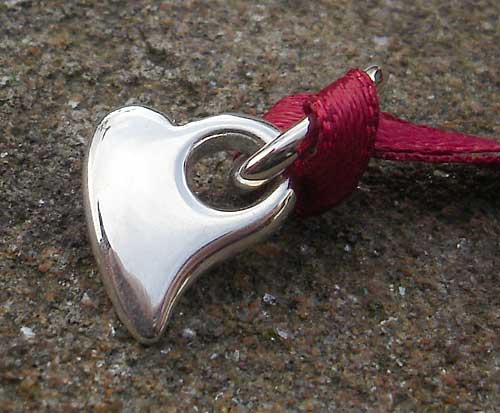 silver heart pendant on red ribbon