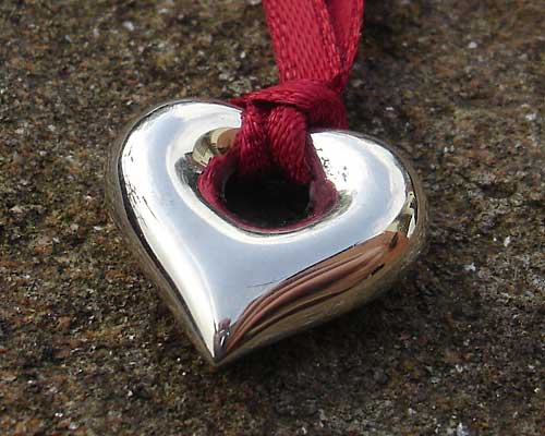 silver heart pendant on red ribbon